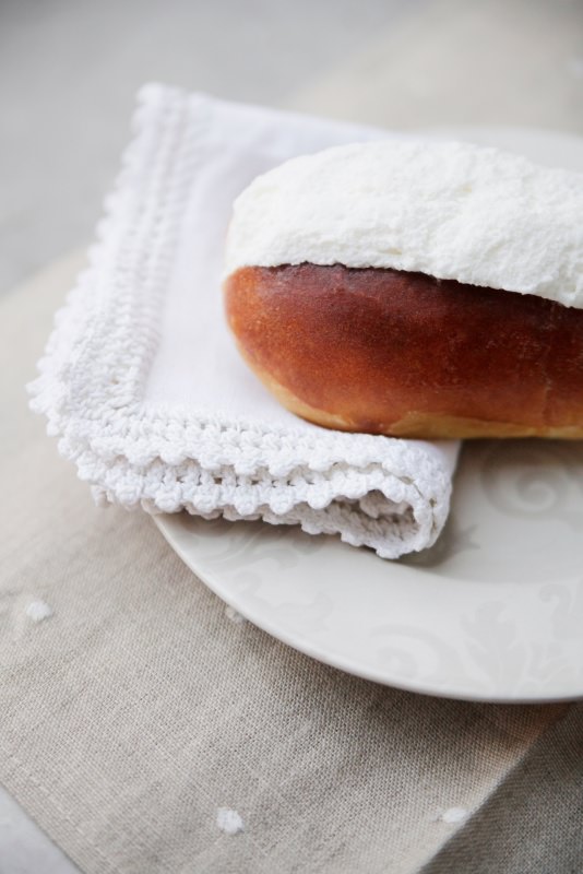 il maritozzo con panna su piattino con tovagliolo e pizzo