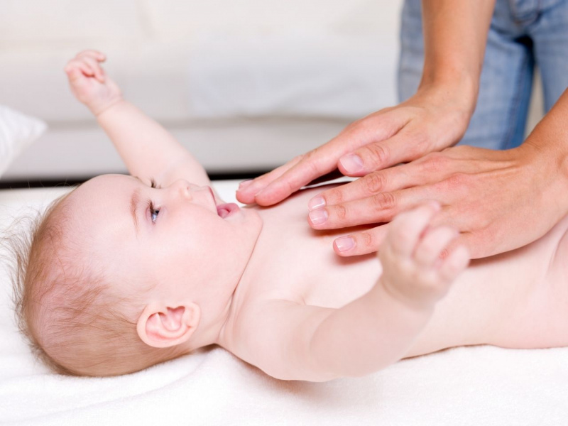 mani massaggiano bebè bambino neonato dopo il bagnetto
