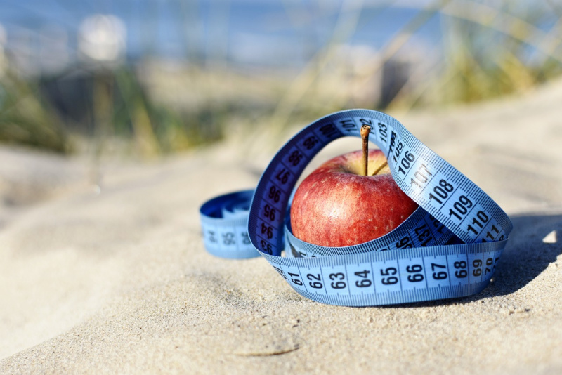 mela rossa metro sarta sabbia spiaggia concetto motivazionale dieta estate