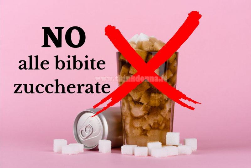 bicchiere di bibita pieno di zollette di zucchero su sfondo rosa lattina alluminio