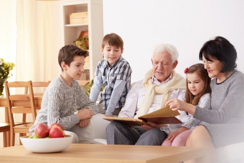 nonni leggono con i nipoti bambini in soggiorno divano 