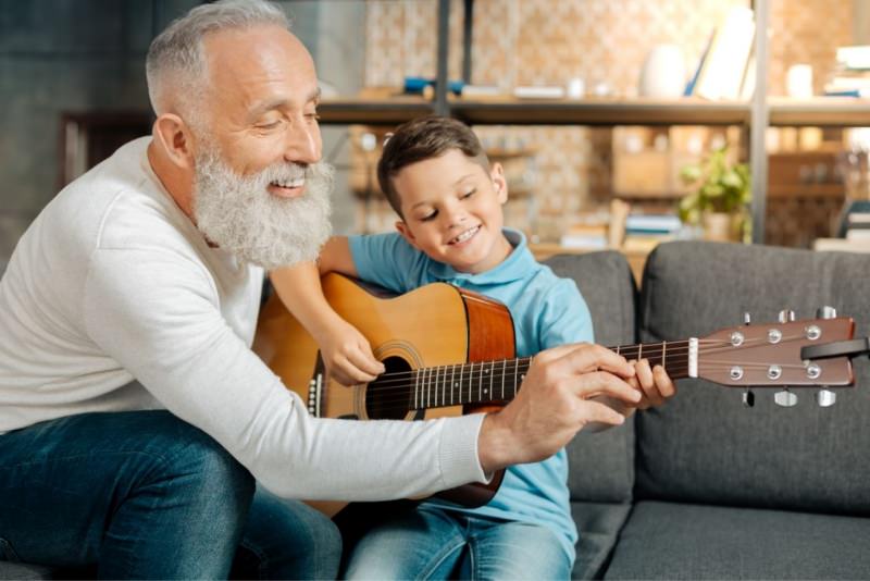 nonno insegna al nipotino a suonare la chitarra