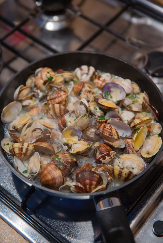 cottura vongole veraci in padella su piano cottura fuoco