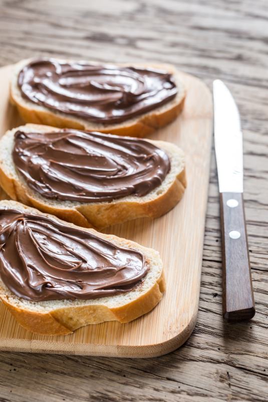 fette di pane con crema cioccolato spalmata nutella su tagliere coltello