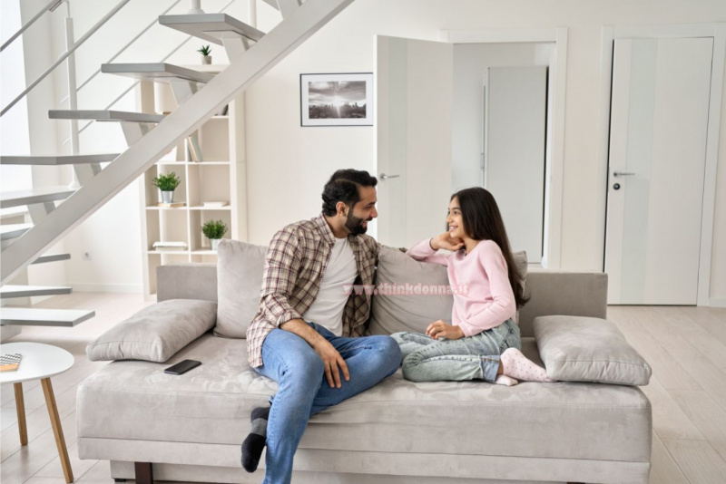 padre e figlia chiacchierano sul divano scala appartamento moderno