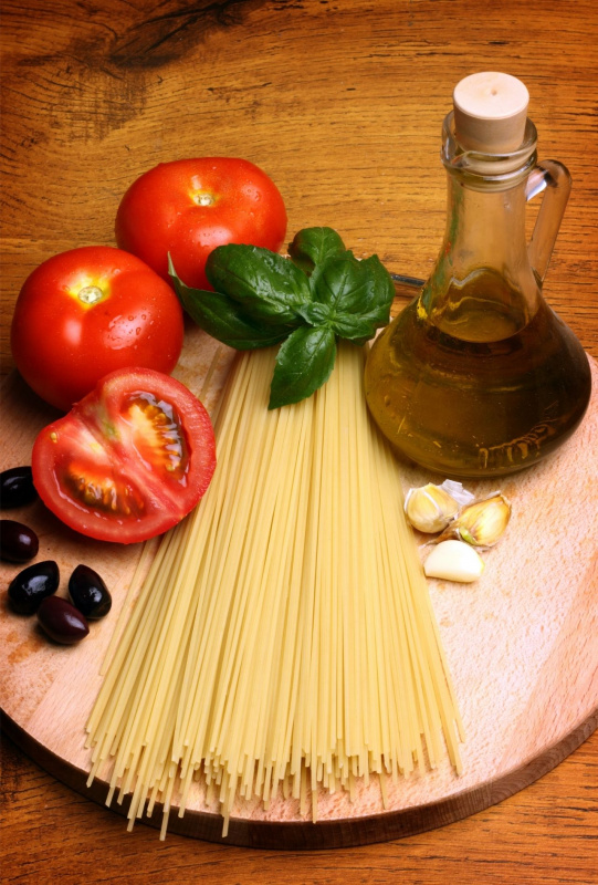 spaghetti pomodoro basilico olive nere bottiglia olio extravergine oliva tavolo legno