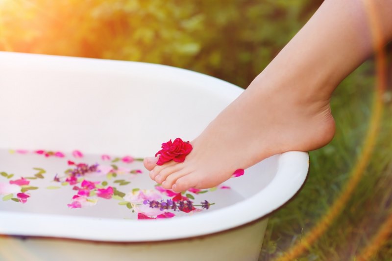 bellissimo piede donna pelle morbida talloni lisci vasca acqua petali rosa fiori