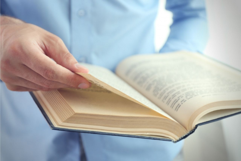 uomo legge libro pagine