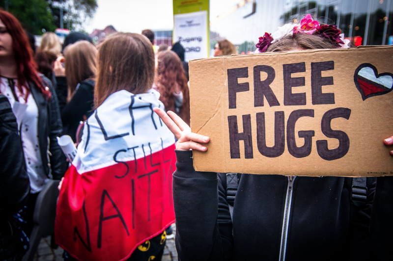 folla di gente giornata abbraccio cartello free hugs persone