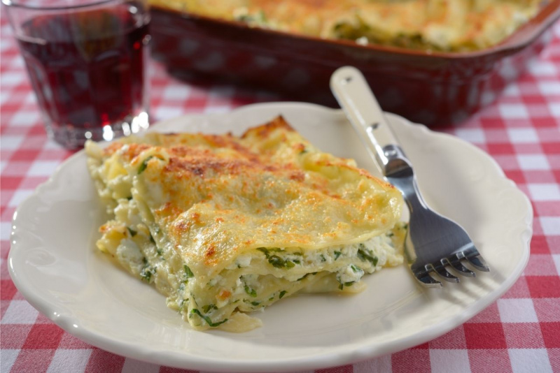 tavola apparecchiata primo piatto bicchiere vino rosso lasagna