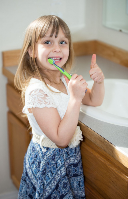 bella bambina felice lavarsi i denti occhi azzurri capelli biondi