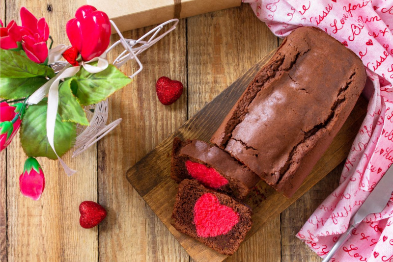 plumcake al cacao su tagliere legno fette tagliate con cuore centro rosso tagliere di legno cuori rossi glitter