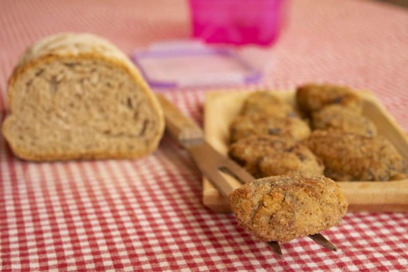 polpette di melanzane fatte in casa piatto pronto tavola pane tovaglia a quadri rosso bianco 