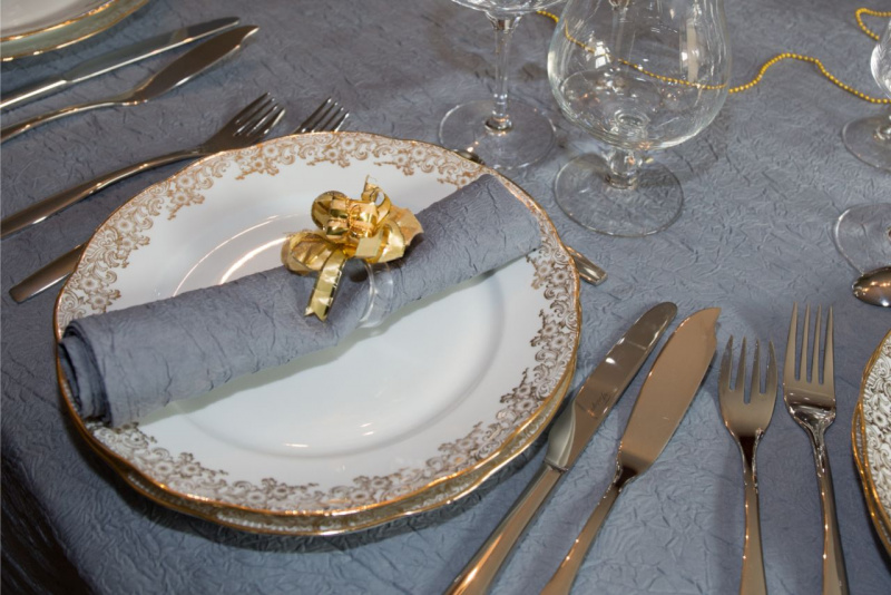 piatti preziosi porcellana bordo oro tovaglia grigia posto tavola apparecchiata notte san silvestro