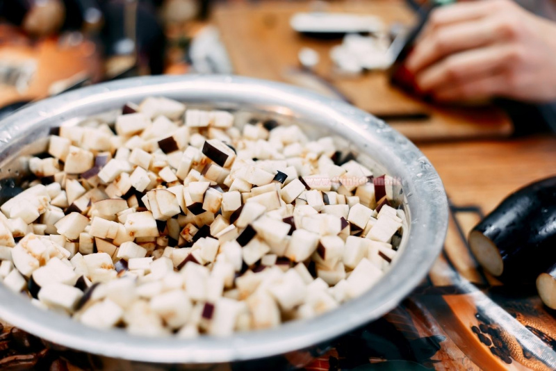 tocchetti di melanzana ciotola tagliere mani donna preparazione caponata siciliana