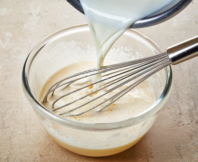 latte versato su composto uova zucchero ciotola frusta crema mousseline