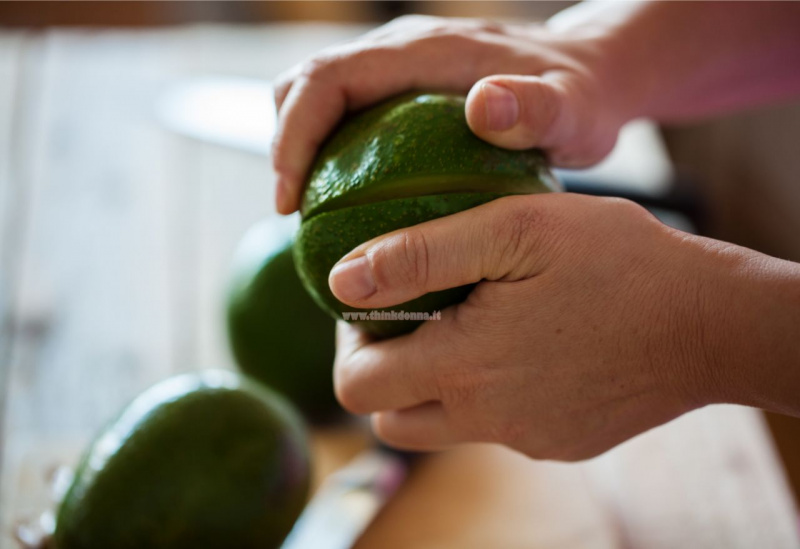 ruotare con le mani avocado tagliato per aprirlo