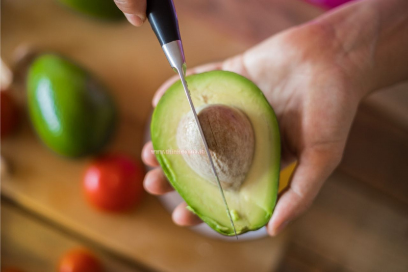 apertura avocado coltello per estrarre nocciolo mani pomodoro rosso