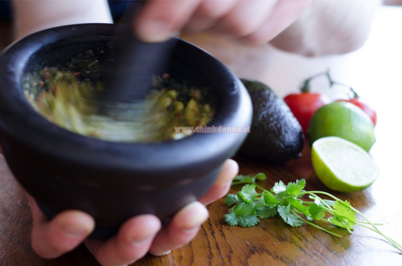 mortaio con ingredienti guacamole pestati con pestello