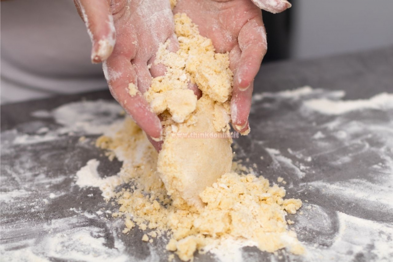 lavorazione a mano pasta frolla su piano lavoro farina