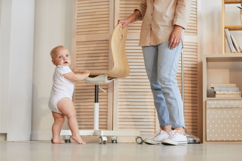 mamma guarda figlio bambino piccolo pericoli casa sedia jeans occhi azzurri