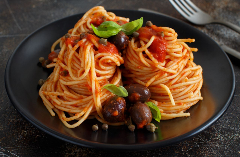 piatto ceramica nera pasta spaghetti olive capperi foglia basilico