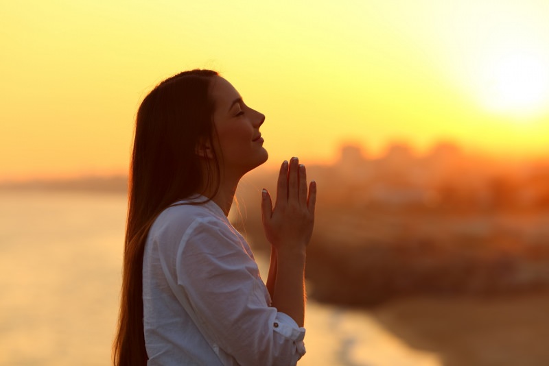 profilo di donna mani giunte prega al tramonto pregare grazie ringraziare
