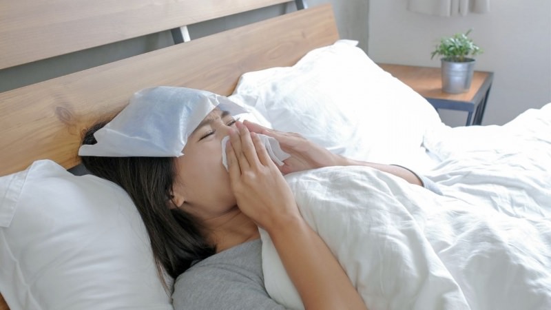 raffreddore donna coricata ltto soffia naso febbre