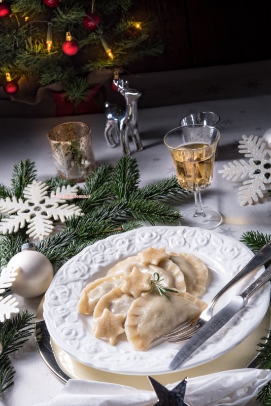 ravioli di pesce primo piatto di magro pronto tavola apparecchiata albero di natale luci renna argento tealight