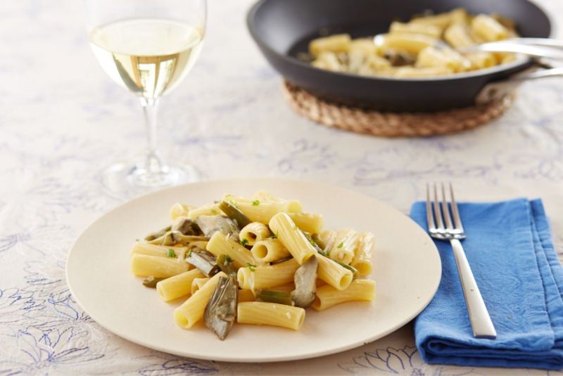 rigatoni saporiti ai carciofi piatto pronto tavola bicchiere calice vino bianco padella