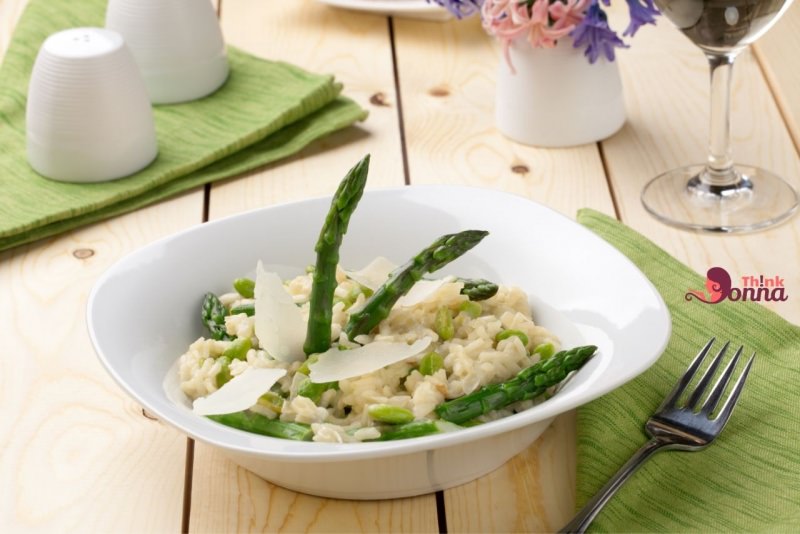 risotto agli asparagi primo piatto pronto in tavola apparecchiata fiori giacinto