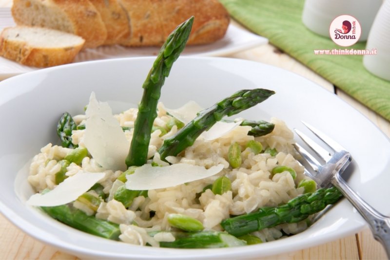 risotto agli asparagi primo piatto pronto in tavola pane primo piano scaglie grana padano