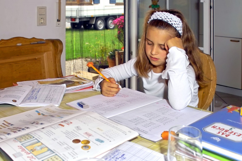 bambina fa i compiti per le vacanze studiare libri quaderno matita gomma