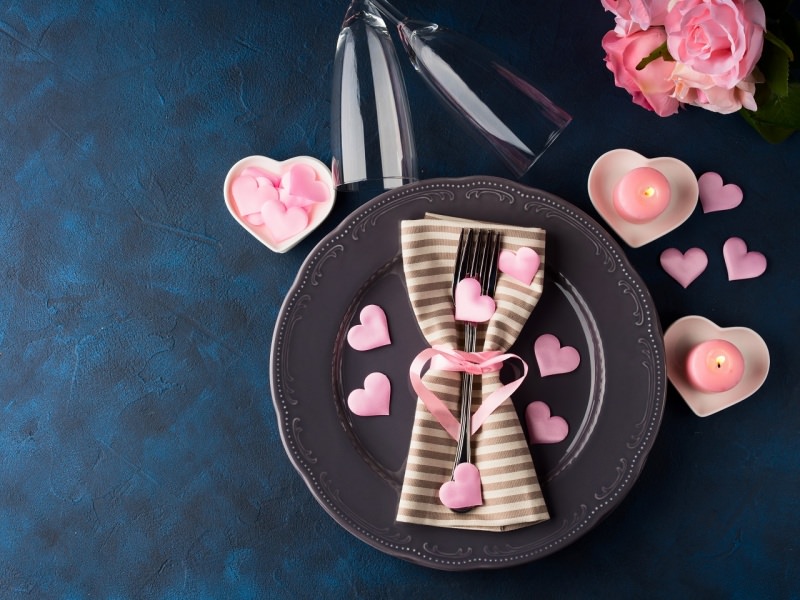 tavola apparecchiata romantica cena san valentino candele a forma di rosa cuori piatto posate 