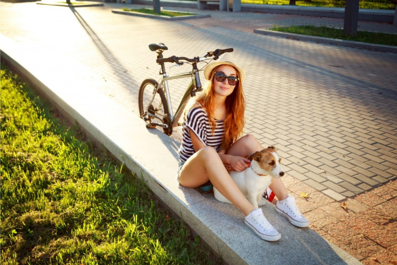 ondata di calore viale giovane donna occhiali da sole protegge cane seduto