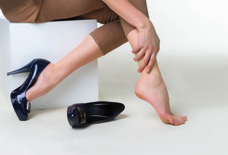 donna si massaggia polpaccio caviglia dolore scarpe tacchi alti