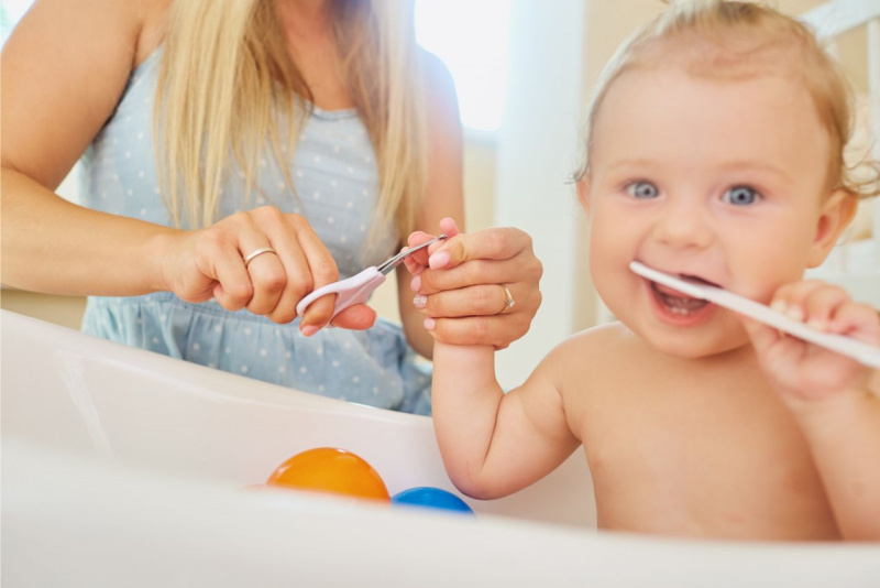cura del neonato igiene tagliare unghie mamma figlio occhi azzurri capelli biondi bagnetto