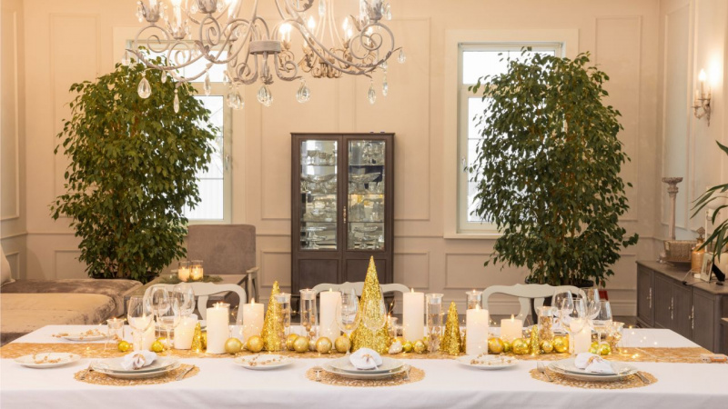 sala da pranzo tavola apparecchiata cena decorazioni oro piante ornamentali