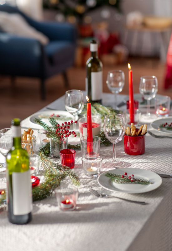 tavola della festa Natale Capodanno tovaglia bianche decorazioni rosse piatti calici