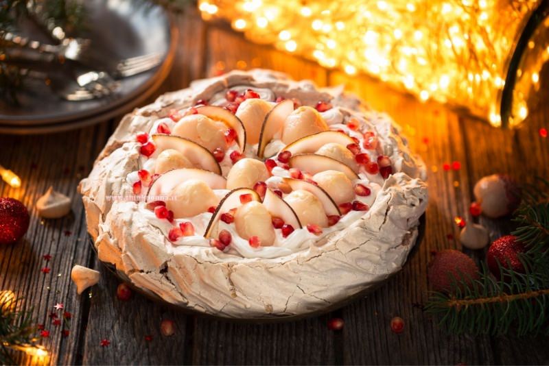 torta pavlova di natale meringa panna montata melograno fette pere luci albero