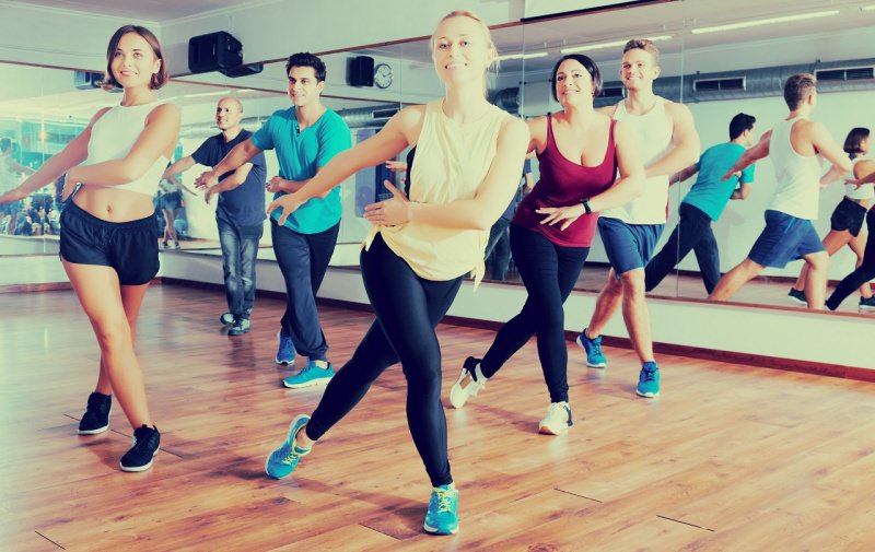 uomini e donna ballano insieme palestra fitness