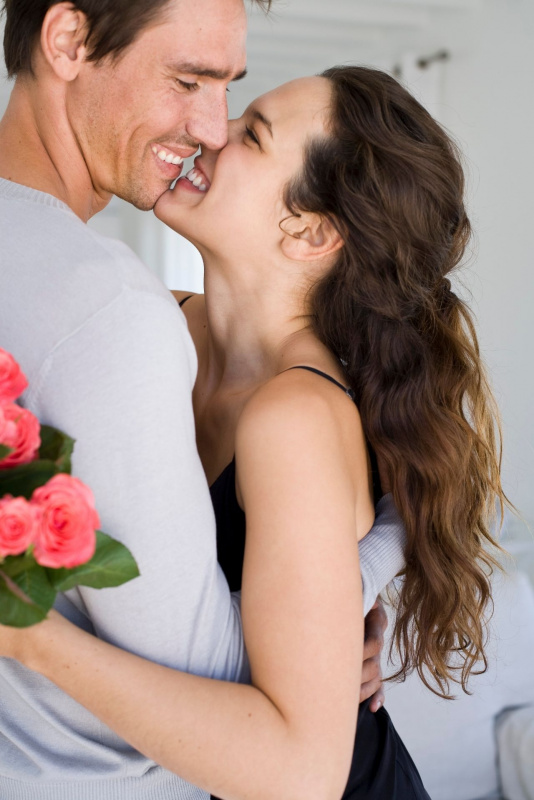 uomo bello donna bella sorri abbraccio coppia intesa bouquet rose