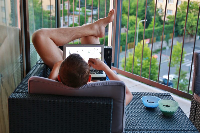 uomo lavora da casa notebook laptop smart working balcone terrazzo 