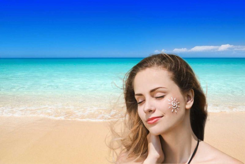 viso donna bella con crema protezione solare a forma di sole mare spiaggia estate sole