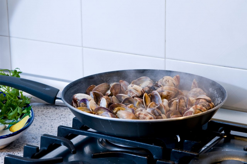 Vongole veraci aperte e fumanti pronte in padella per il condimento degli spaghetti alla vigilie di Natale.